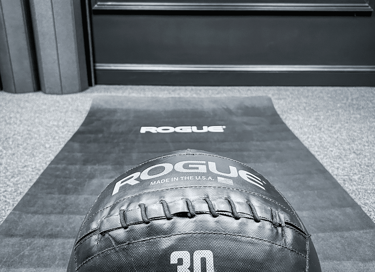 A Rogue medicine ball on the training mat at Hustle House Health & Wellness in Woodstock, GA