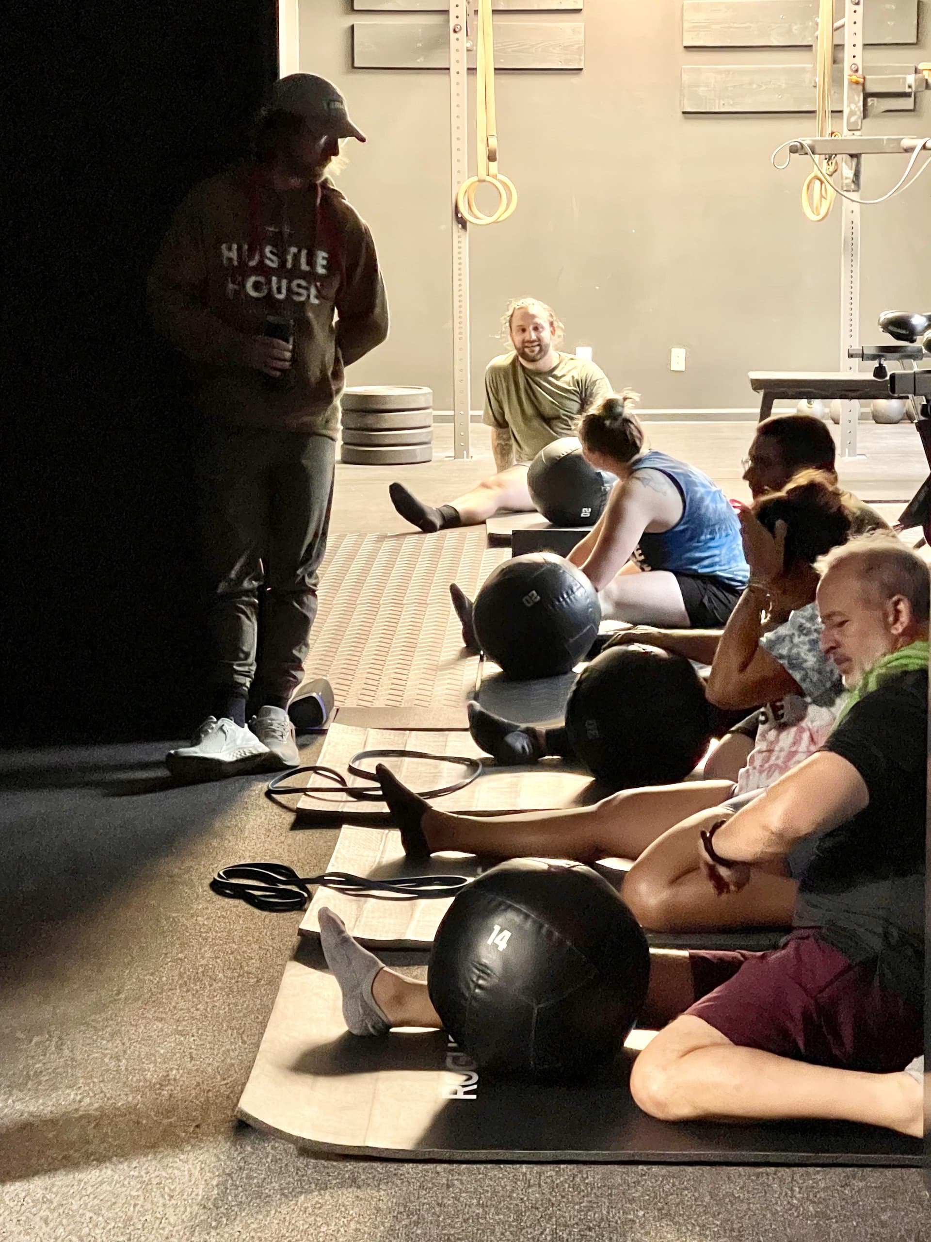 A member taking a water break near the studio entrance at Hustle House Health & Wellness in Woodstock, GA