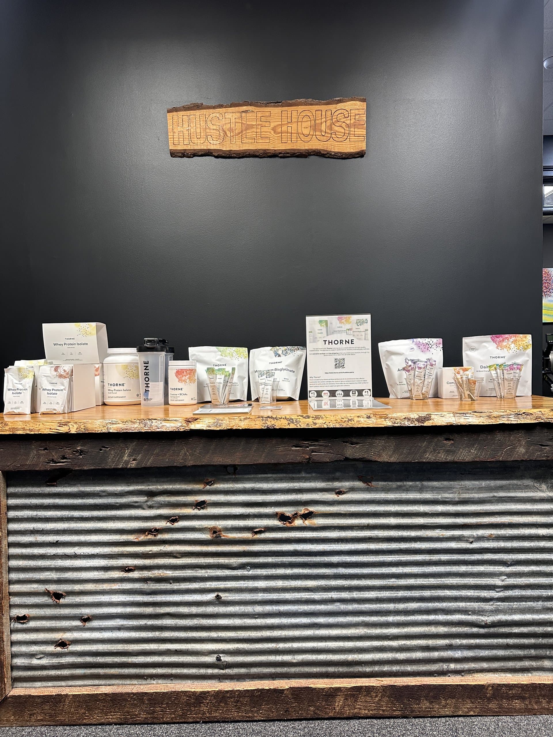 The supplement shelf on the front counter at Hustle House Health & Wellness in Woodstock, GA
