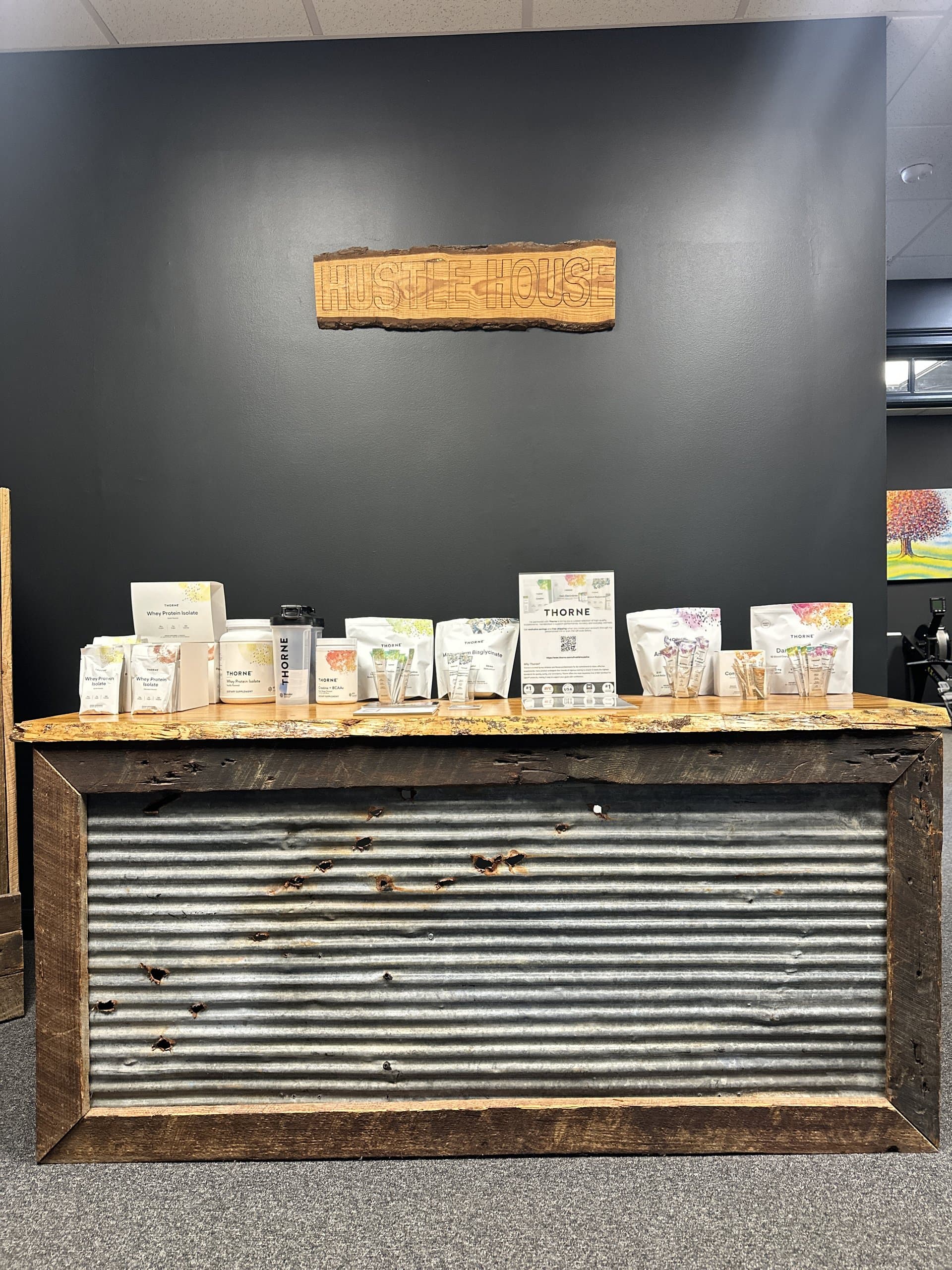 The front counter and supplement shelf beneath the Hustle House sign in Woodstock, GA